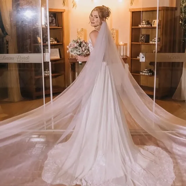 Noiva de costas, mostrando vestido e véu, no estúdio de Fábia Nogueira
